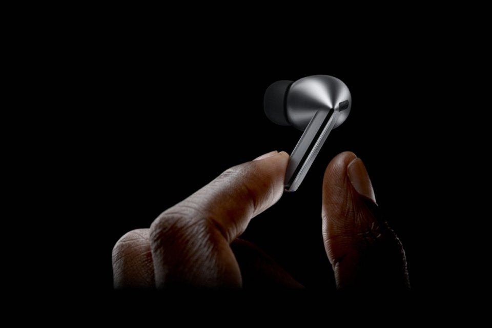 Fingers holding up a Samsung Galaxy Buds3 Pro earbud.